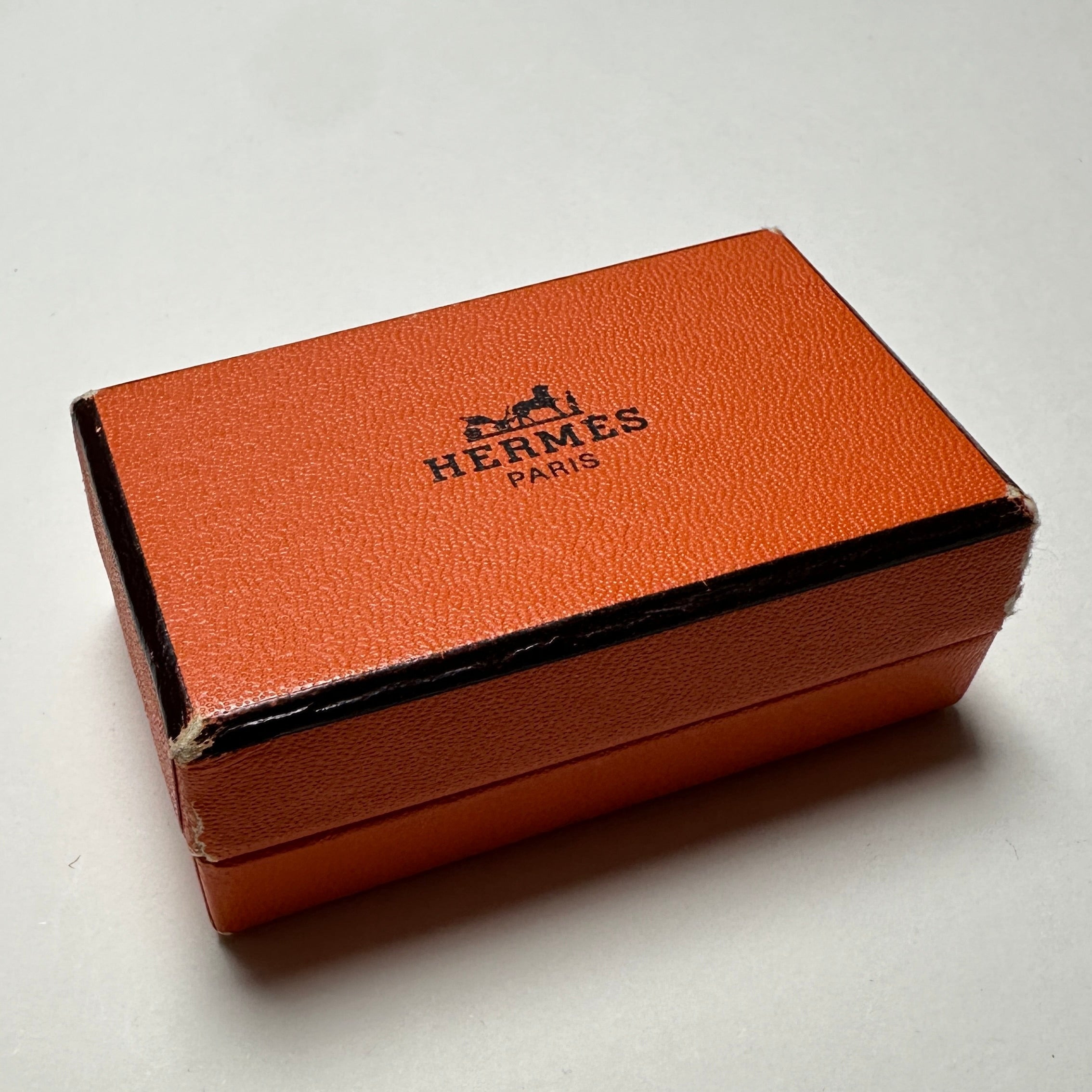 ue de la boîte orange Hermès vintage d'origine fermée, avec le logo "Hermès Paris" et le dessin de la calèche sur le couvercle.