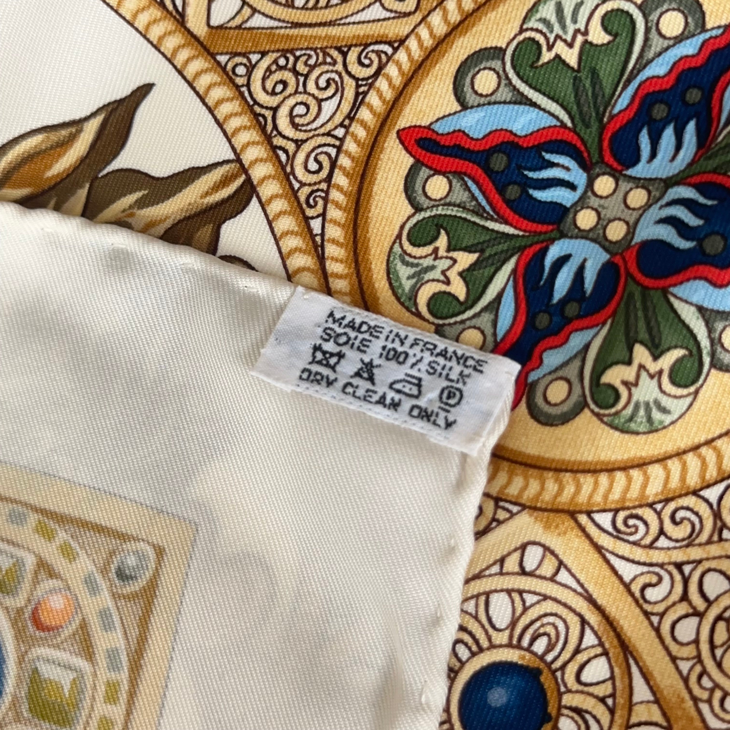 Zoom sur l'étiquette de composition "Made in France 100% Silk" cousue sur l'envers du roulotté, garantissant l'authenticité de la pièce.
