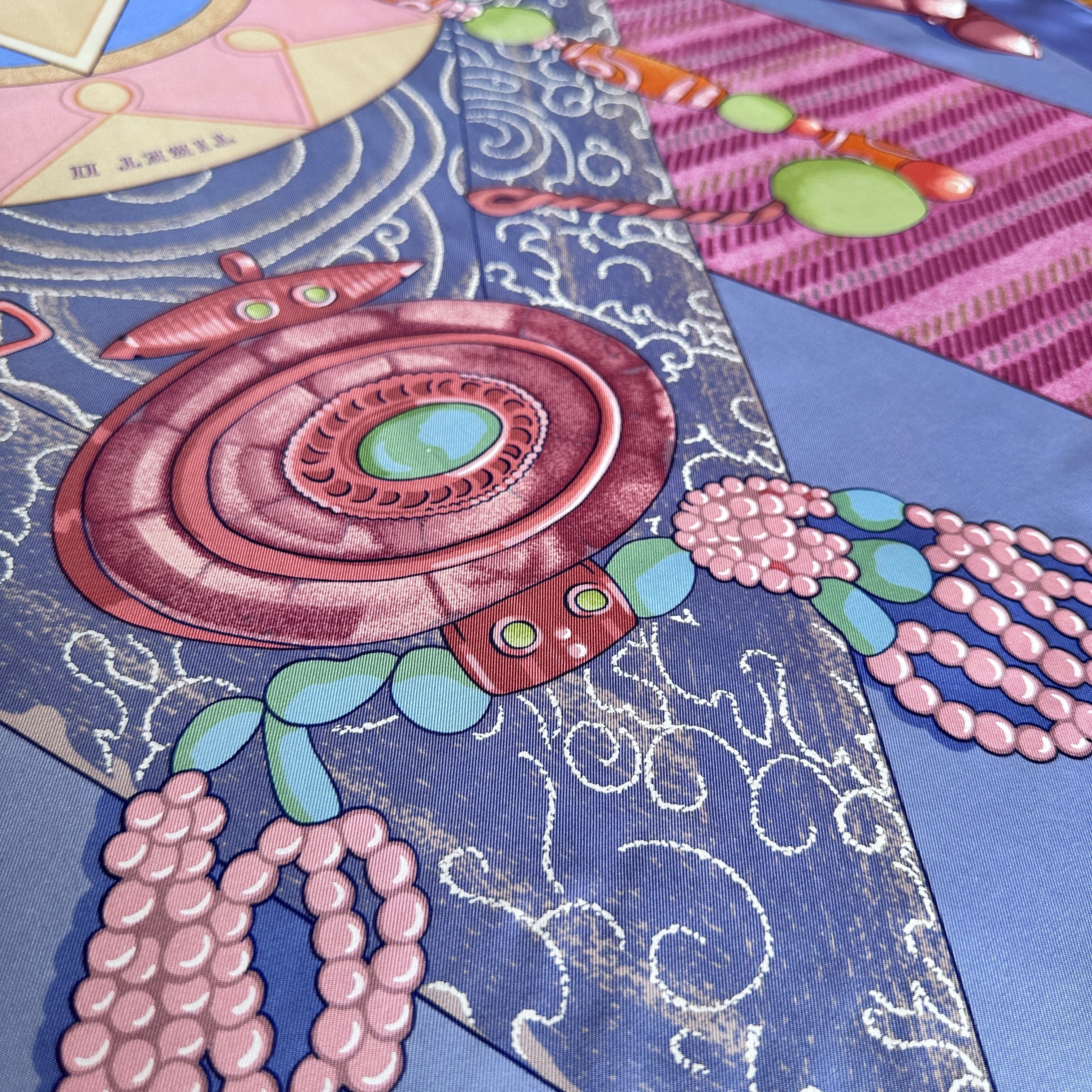 Détail des motifs floraux et colliers de perles sur soie bleue.