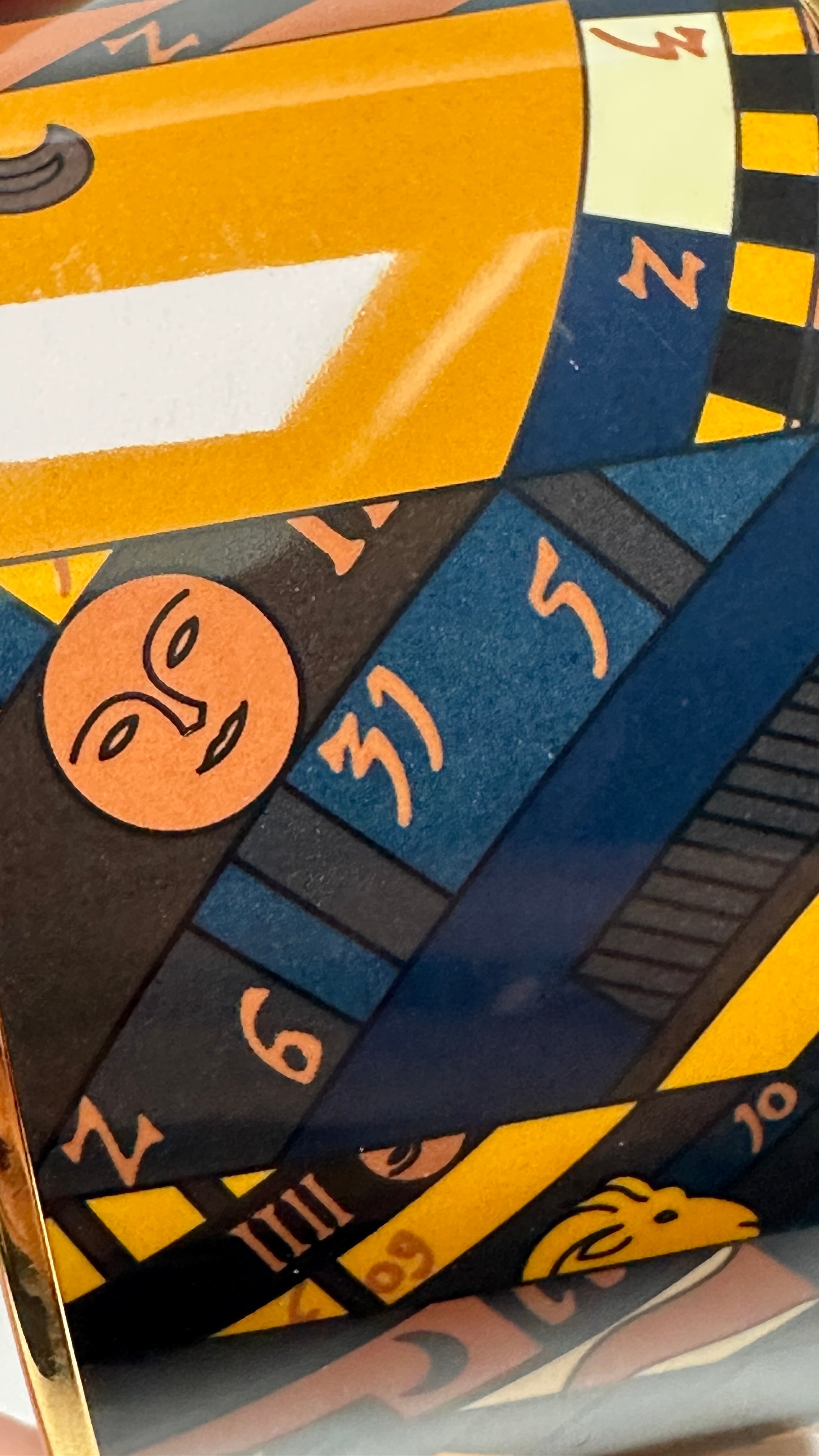 Gros plan motif soleil et zodiaque sur émail Hermès Astrologie Nouvelle